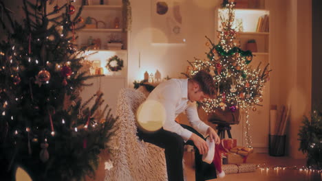 upset man sitting on chair at illuminated home during christmas