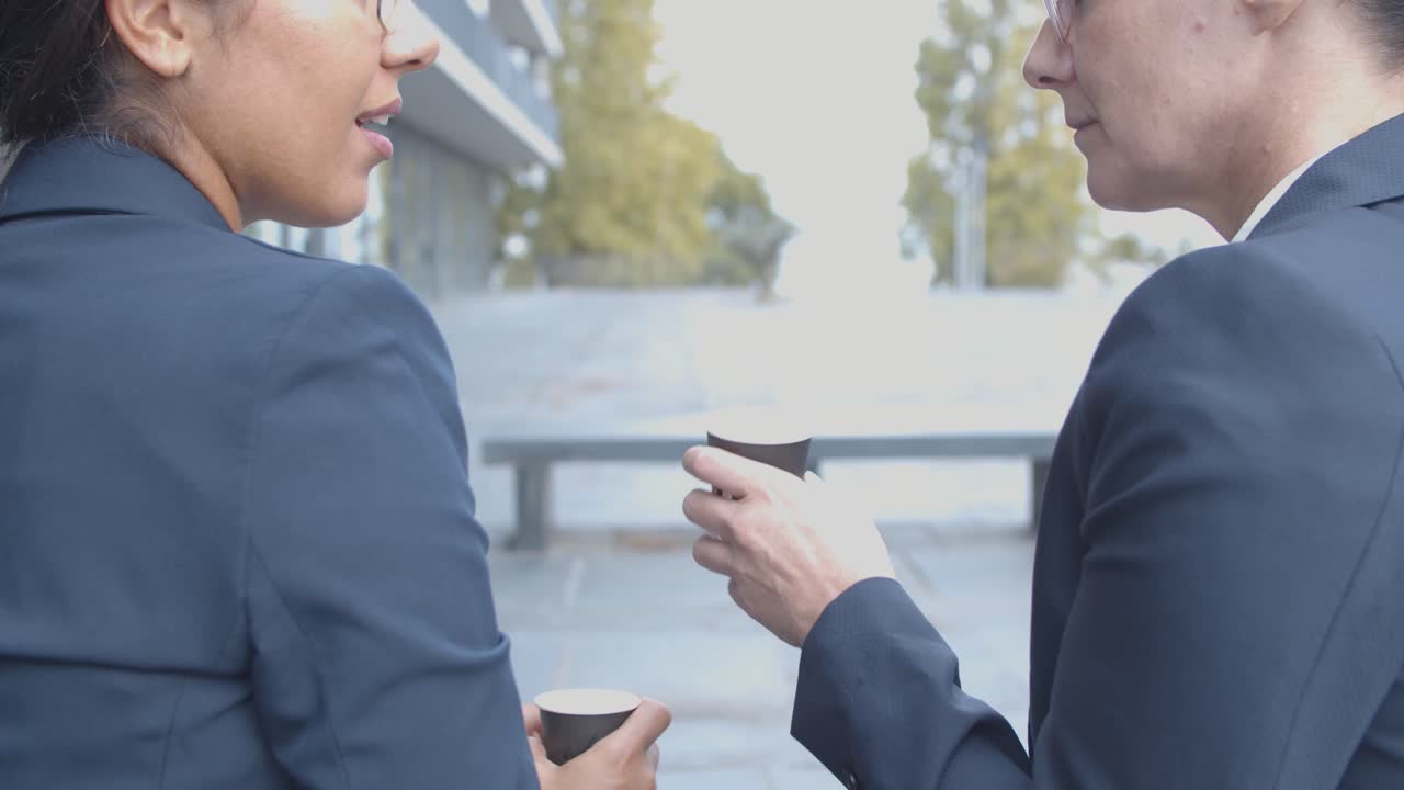 밖에서 쉬는 시간에 커피를 마시고 이야기하는 경제인의 뒷모습