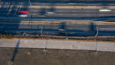 A-top-down-time-lapse-over-a-park,-next-to-a-highway