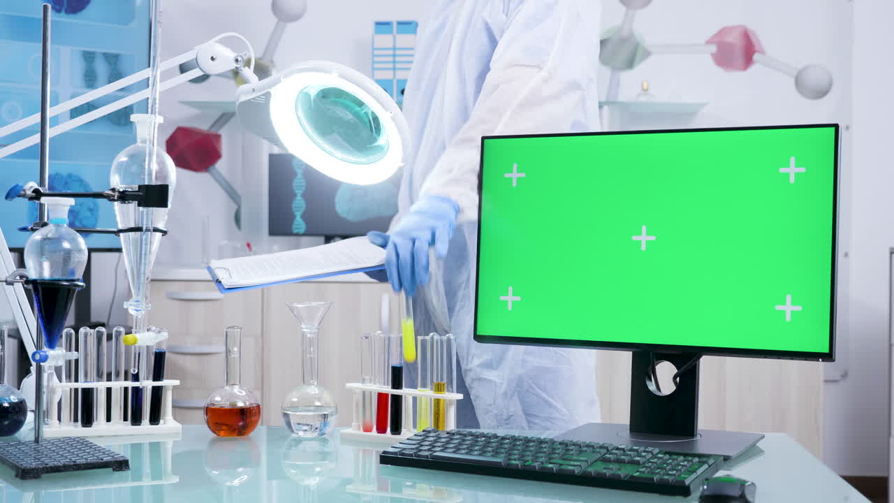 Scientist in laboratory with computer and test tubes