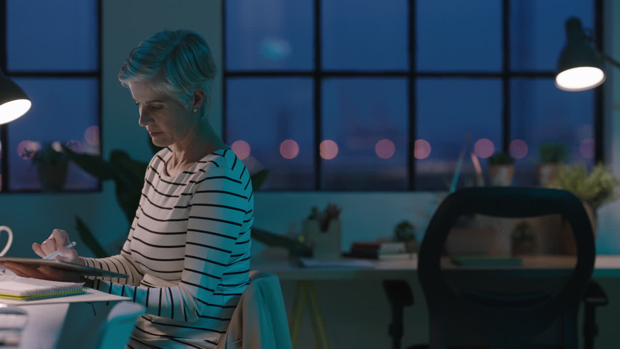 senior business woman using tablet stylus drawing working late successful entrepreneur busy on touch pad device dedicated mature female in start up office workspace
