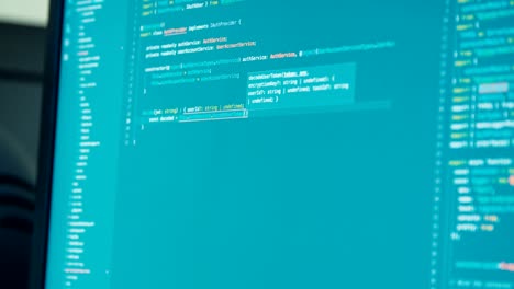 computer programmer sitting in front of a screen coding software