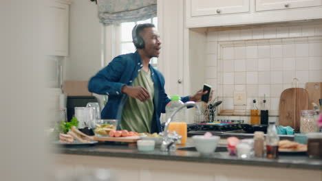 Feliz-Hombre-Afroamericano-Bailando-En-La-Cocina-Escuchando-Música-Usando-Audífonos-Divirtiéndose-Celebración-De-Baile-Disfrutando-El-Fin-De-Semana-En-Casa