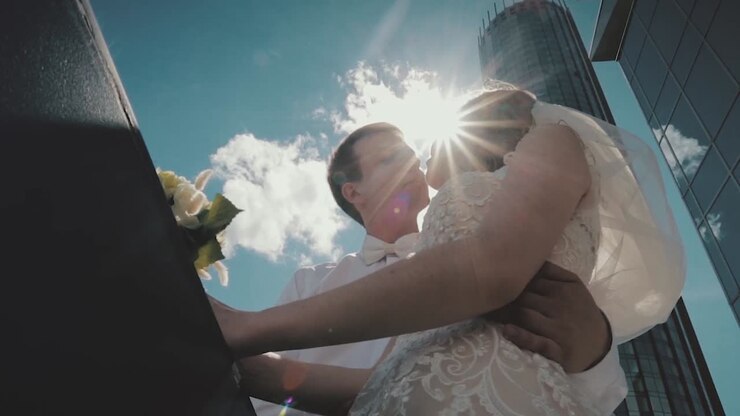 Couple Kissing in Front of Skyscrapers on Their Wedding Day