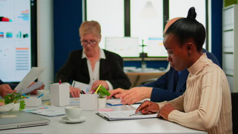 mujer de negocios africana leyendo documentos, firmando sus