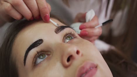 caucasian woman lying down having her eyebrows dyed