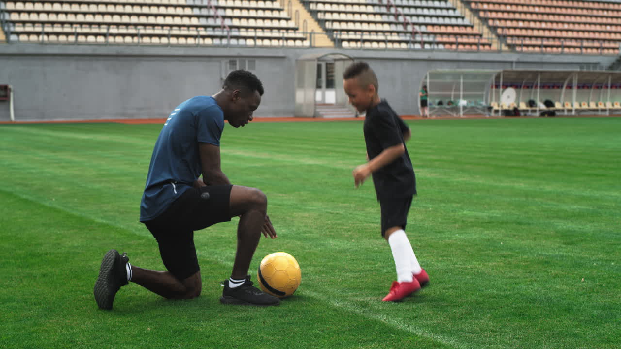 Soccer Coach Training a Young Boy on a Stadium Field