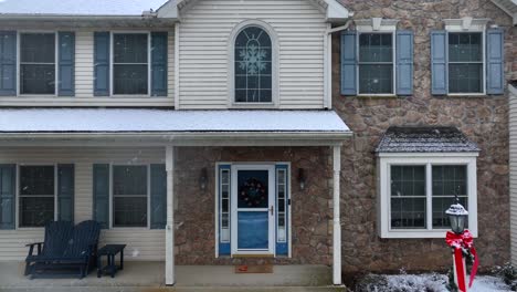 traditional two story home with joy sign in yard at christmas