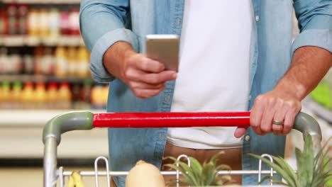 Hombre-Mayor-Enviando-Mensajes-De-Texto-En-El-Supermercado