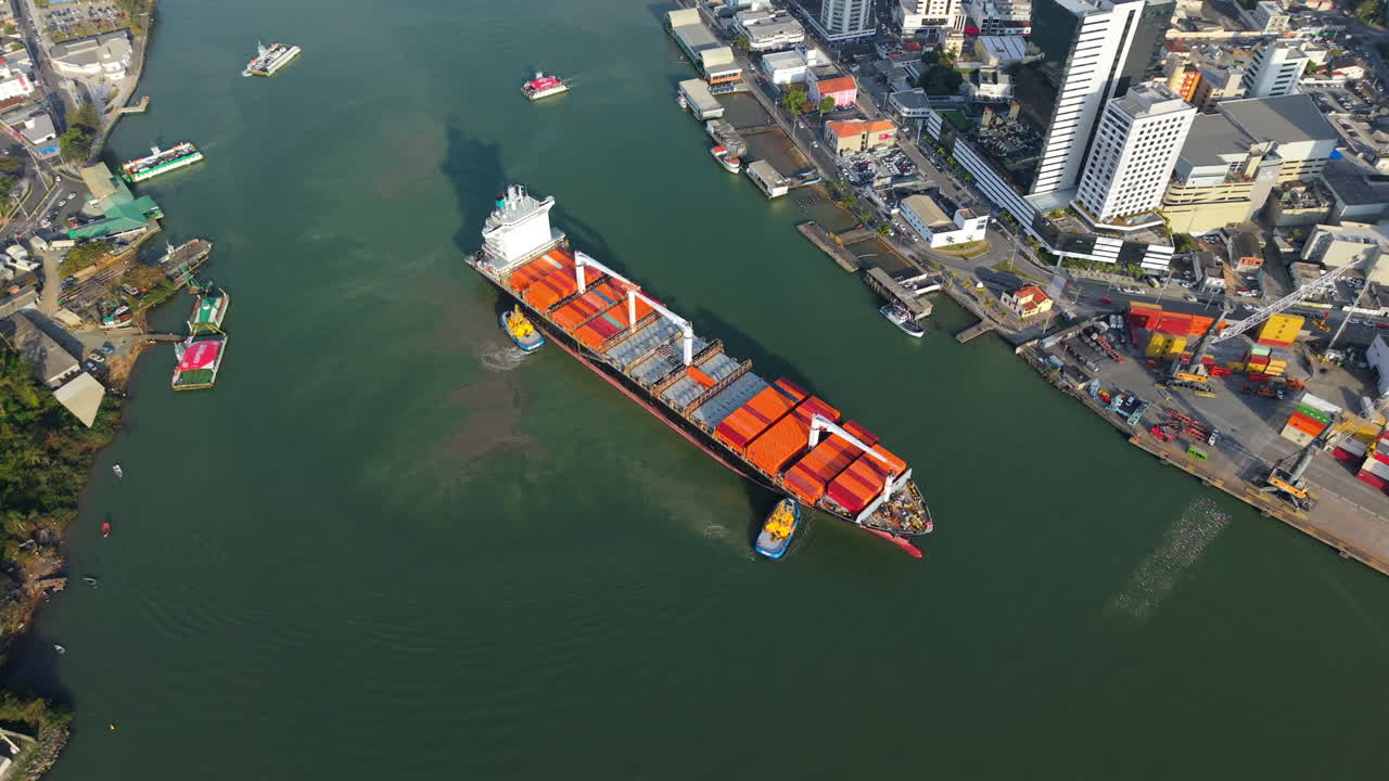 Cargo ship navigating through a narrow waterway near a coastal municipality port area of Itajaí, Santa Catarina, Brazil