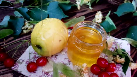 pouring honey on red apple and red apple slice on white plate with honey isolated on a white background. symbols of jewish new year - rosh hashanah.