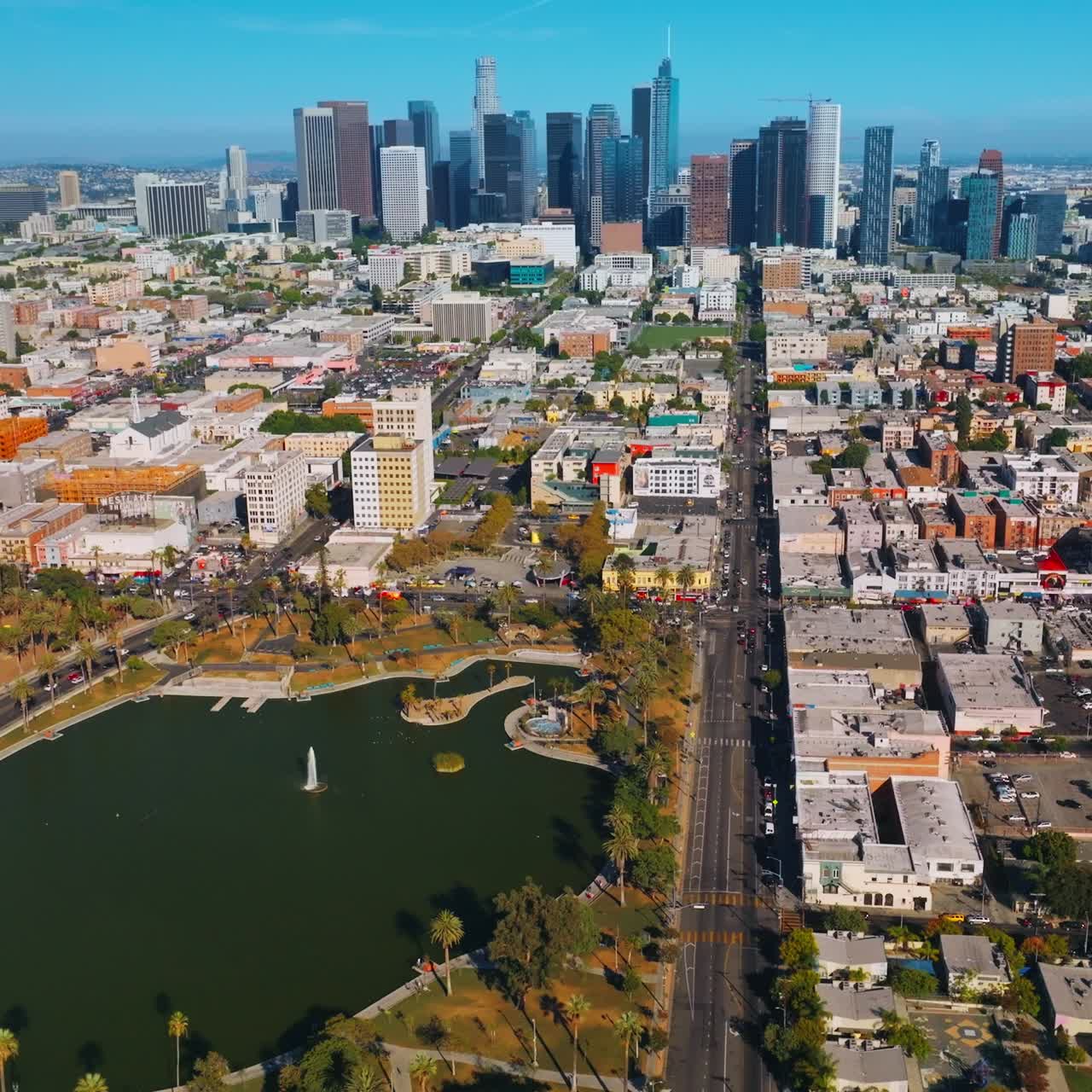 Green pleasant park amongst dense architecture of the city. Beautiful skyscrapers standing out in the panorama of sunny Los Angeles. Top view