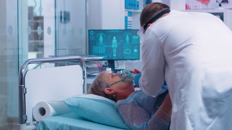 el médico pone una máscara de oxígeno en un paciente anciano.