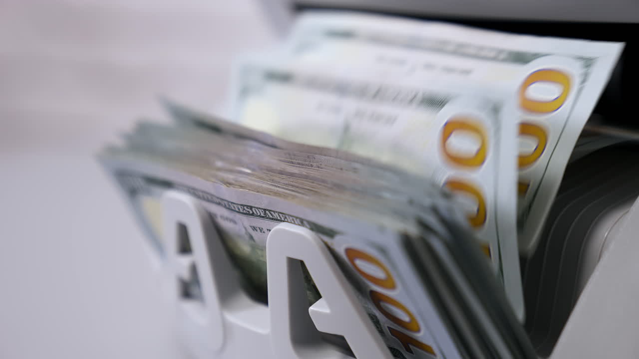 Automatic calculation of paper money. Detailed view of Us dollar banknotes on currency counter machine. Business economy of usa. Macro shot.