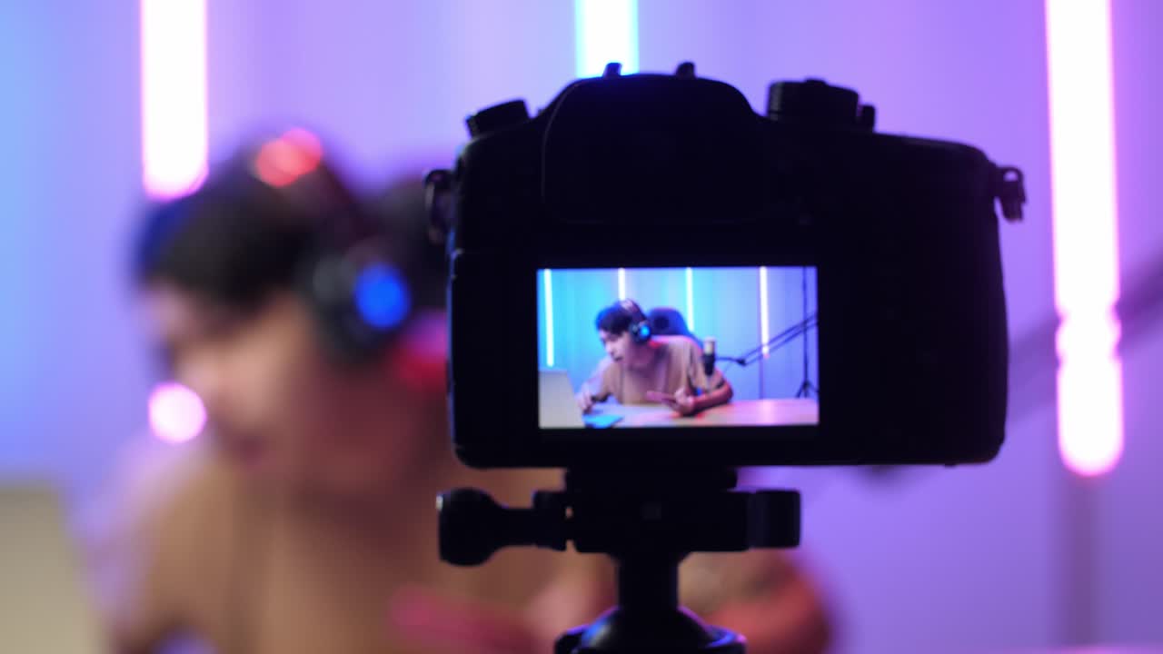 Display Camera Of  Asian Man Holding Mobile Phone And Read Comment In Laptop Computer Then Talking To Camera While Live Stream