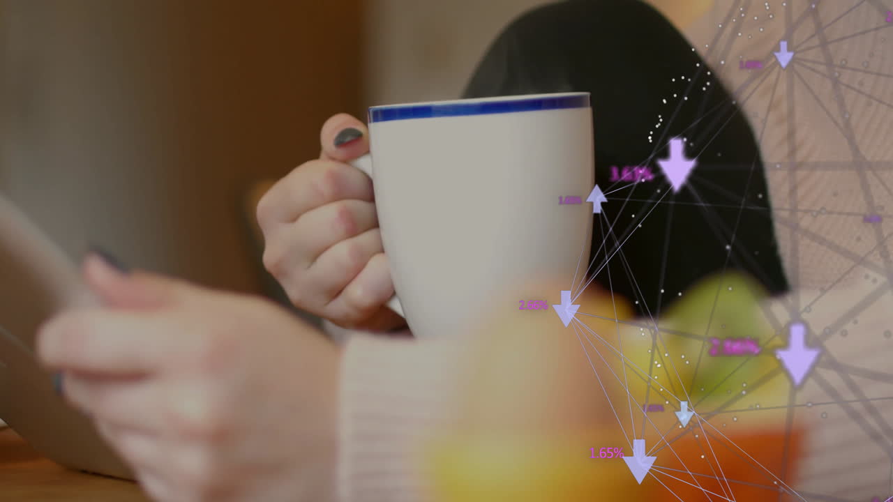 Man holding mug and tapping device at wooden table, showing digital analytics graphics overlay