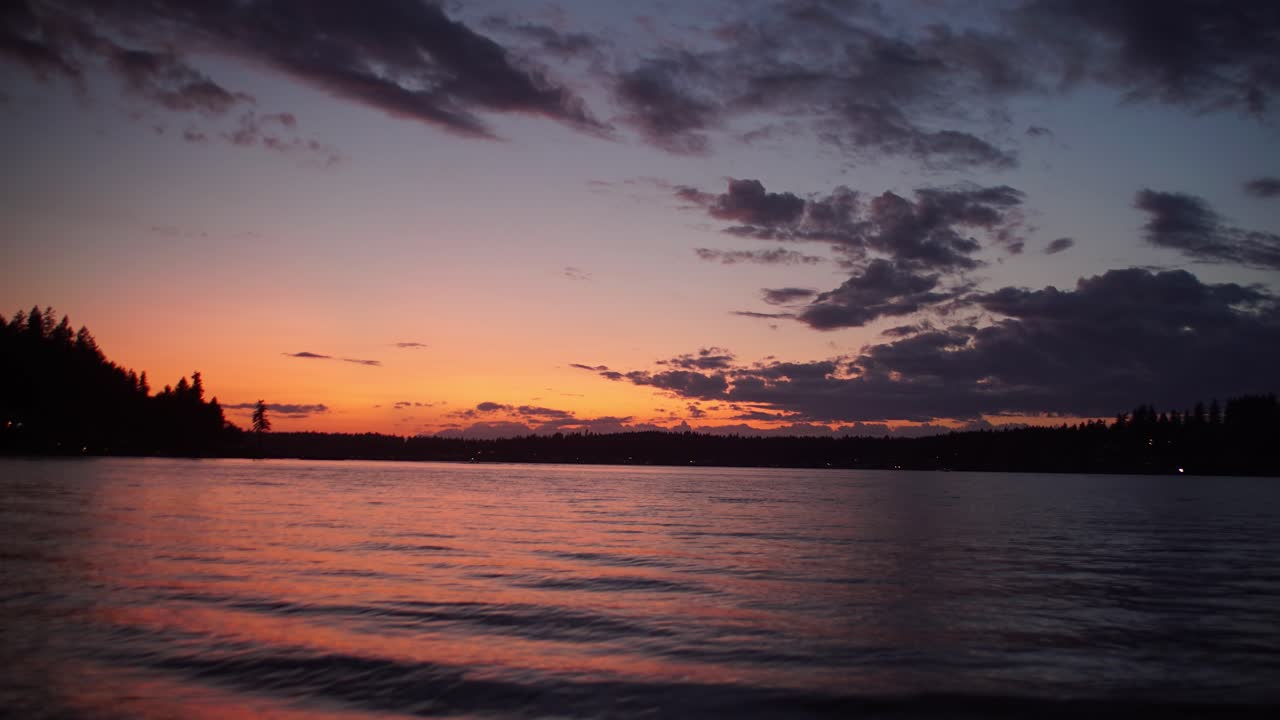 Slow pan down and out of amazing sunset seen from Fox Island Washington, hyper time lapse