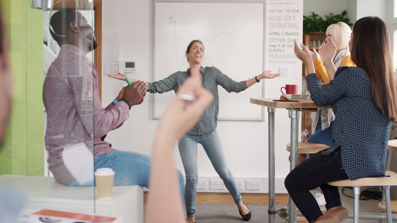 미친 행복한 사업가 여자가 춤을 추고 팀 회의에서 승리의 춤을 추고 성공의 성과를 축하합니다.