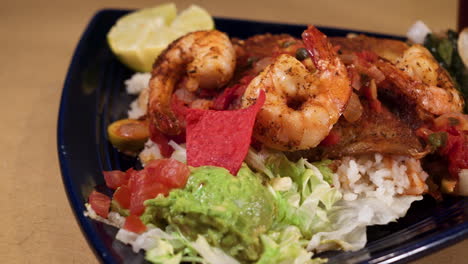 mexican shrimp and fish over rice on blue triangle plate, slider close up hd