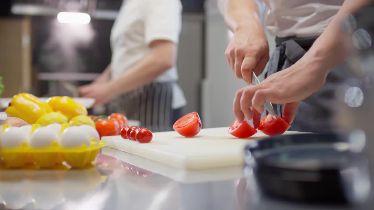 Chef Cutting Tomato in Restaurant Kitchen
