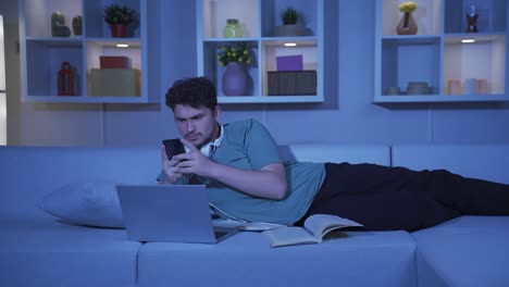 hombre adicto al teléfono en casa por la noche.