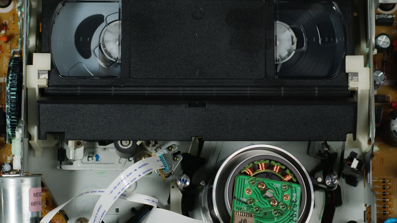 Old video recorder inside close-up, VHS. Retro player in neon blue light, vintage video cassette broadcasting, audio tape.