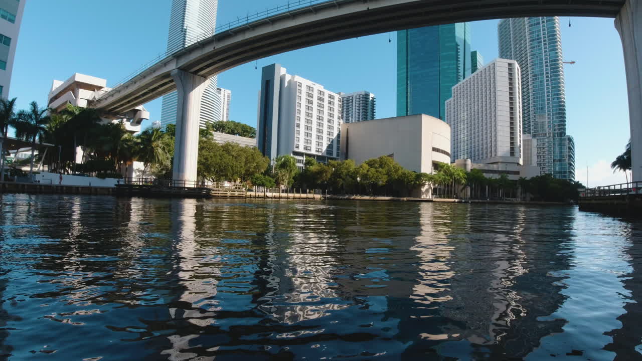 ⁇ 은 날 마이애미 플로리다의 수로에서 높은 건물을 향해 다리  ⁇ 을 지나가는 작은 보트에서의 전망