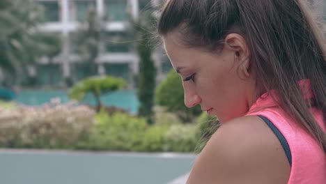 calm-woman-in-blouse-stands-against-blurred-tropical-hotel