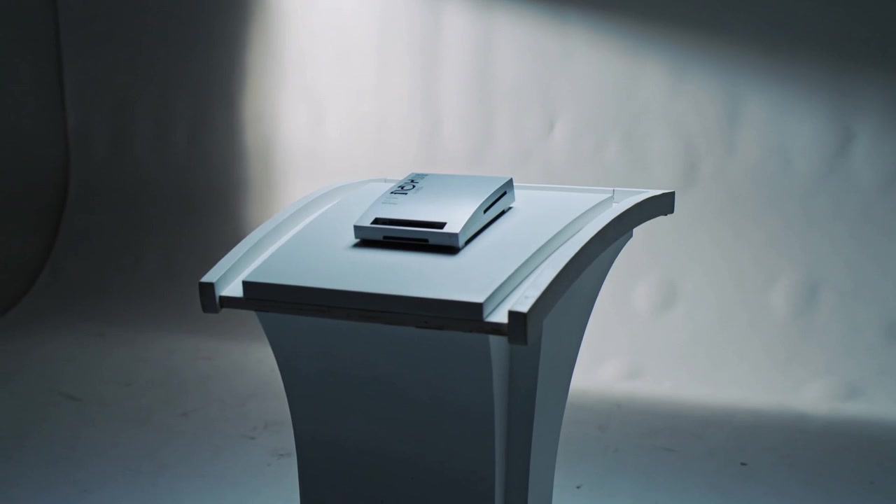 Moving camera rotating to right in studio, revealing device vents, pedestal, and cable