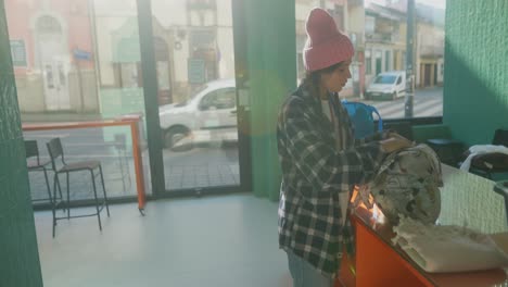 young woman checking/putting bags in a cafe