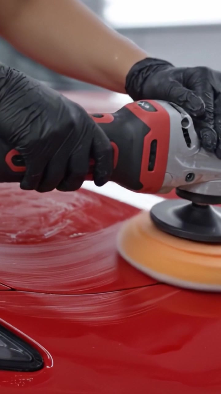 Detailing and Polishing a Sleek Red Car with Careful Movement, Focused on the Shiny Surface and Expert Technique for a Flawless Finish.