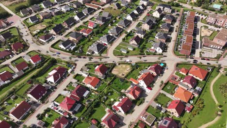 residential area, uniform single family houses with green gardens in a small town, sunny day, drone