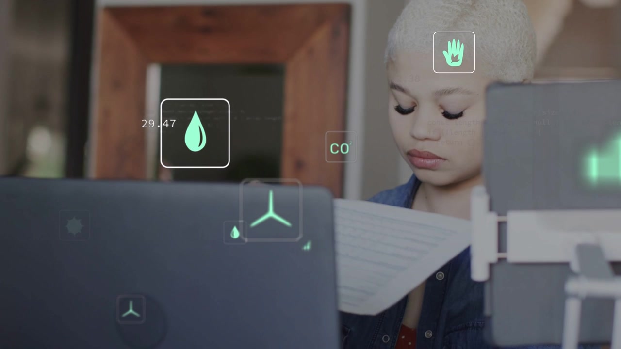 Woman typing laptop, pulling eco print, inspecting pages as AR charts overlaying laptop and paper