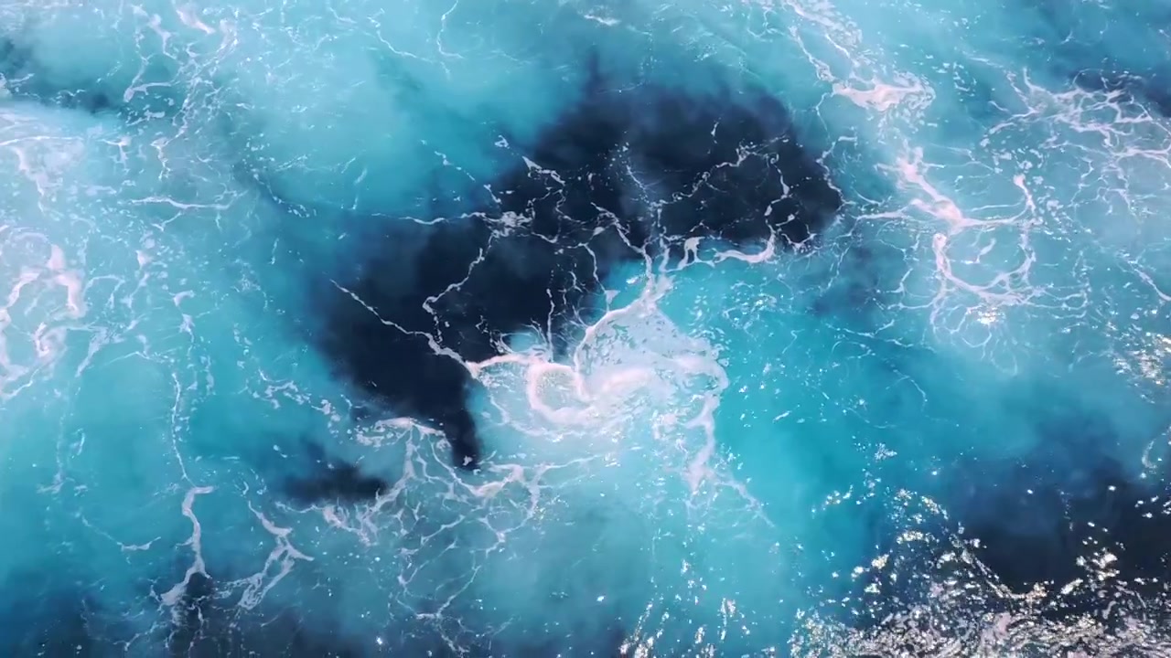 Vista dall'alto dell'acqua turchese dell'oceano e della schiuma bianca