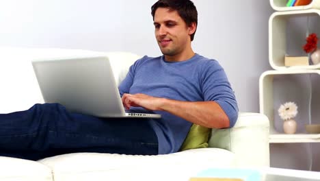 Calm-casual-man-using-his-notebook-sitting-on-couch