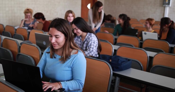 Young Woman Using Laptop in University Lecture Hall