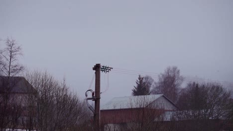 Transmission Line And House Roofs With Fog Clouds In Background