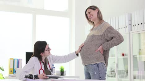 doctor touching pregnant woman's belly during a medical consultation