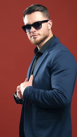 side view of entrepreneur in glasses. handsome bearded man in stylish costume isolated in studio. young businessman in black glasses indoors. vertical video