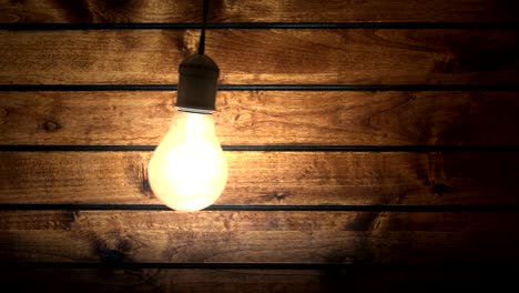 swinging incandescent bulb in timber-house darkened room, seamless loop