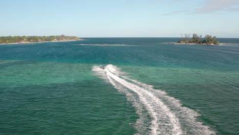 lancha rápida dejando rastro en el mar azul navegando a la isla en honduras