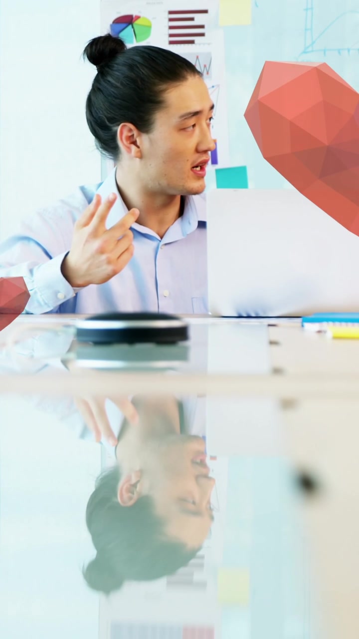 Young Asian Man Working and Presenting with Animated Hearts in Office