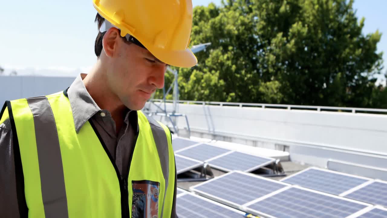 trabajador masculino usando una computadora portátil en la estación solar 4k