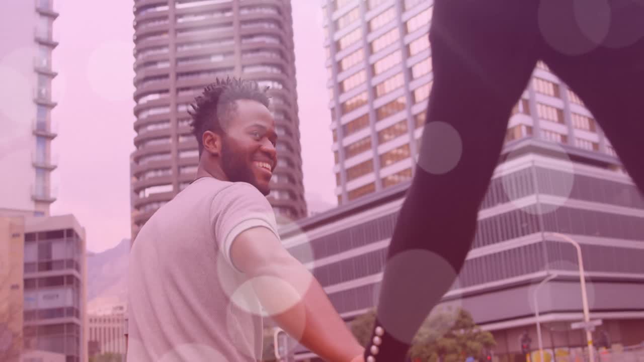 Animation of light spots over african american couple walking and holding hands