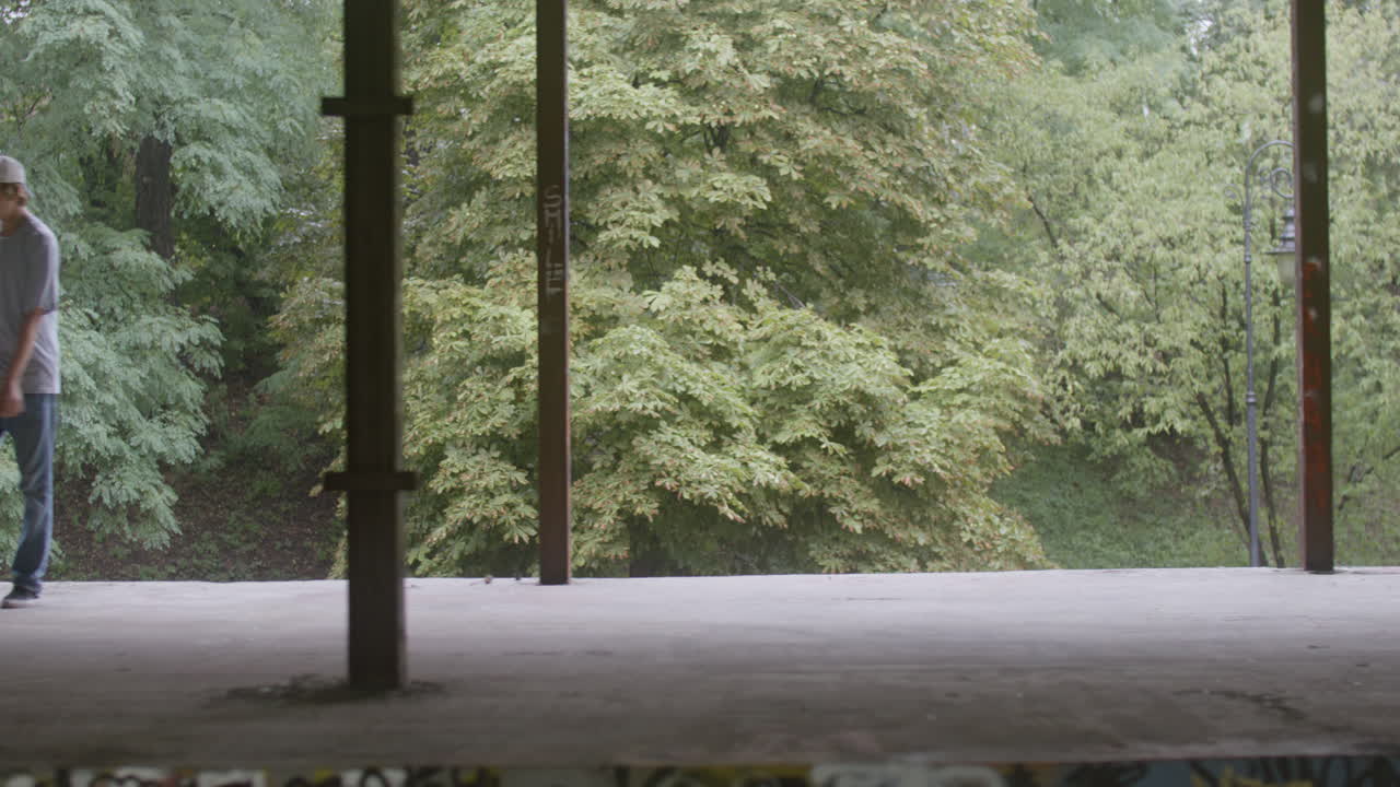 백인 소년이 폐허가 된 건물에서 스케이트보드를 타고 있습니다.