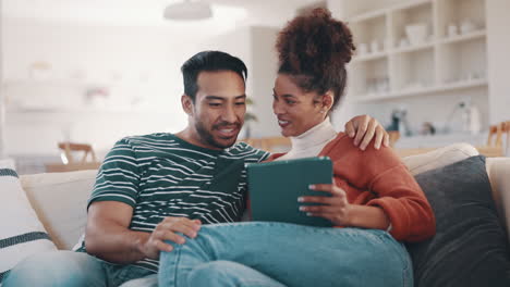 happy couple on sofa with tablet