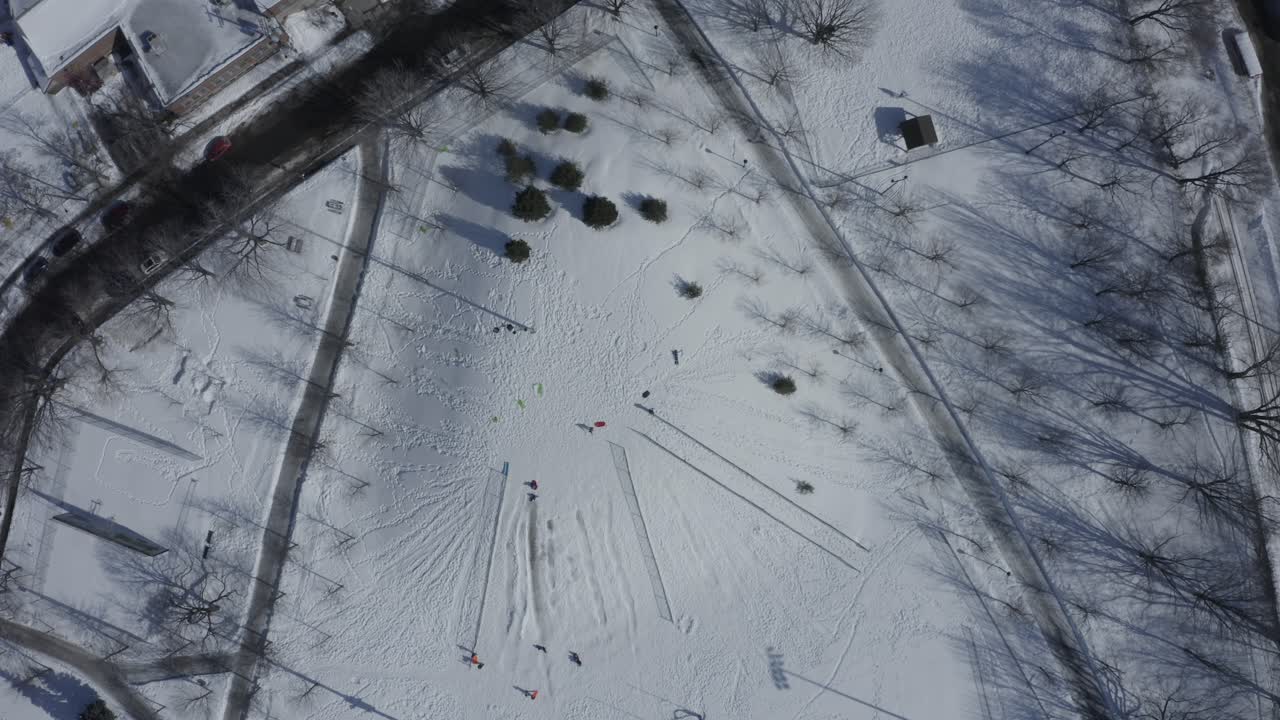 ángel en la nieve, parque en un frío día de invierno - madre e hijo - drone - cinemática - vista superior de 4k bajando