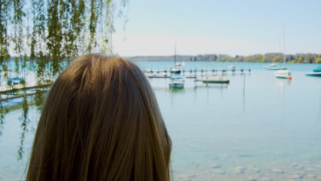 Mujer-Rubia-Está-Parada-Frente-A-Un-Lago-Pintoresco