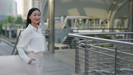professional asian woman standing on an urban walkway