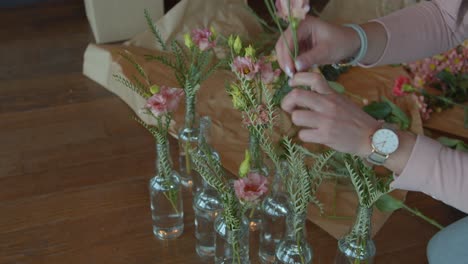 female preparing many flower bouquets for decoration, handheld view